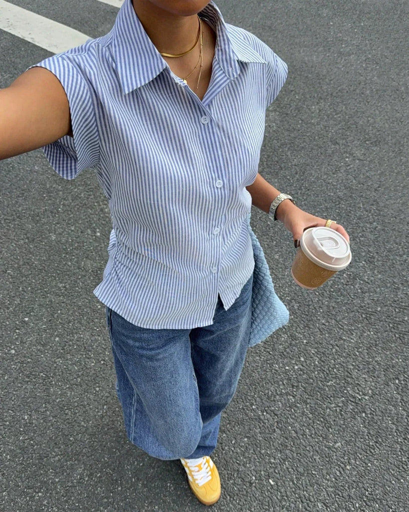 a sleeveless blue and white striped button-down shirt