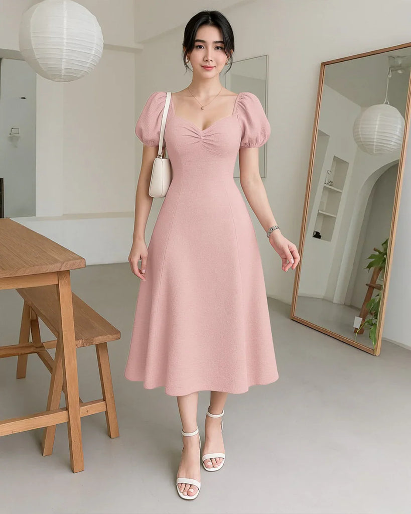 Powder pink cotton dress with puff sleeves and cinched waist, perfect for summer elegance.