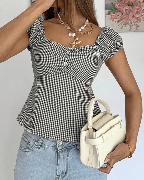 Women wearing Black and white checkered top with sweetheart neckline, short puff sleeves and slim fit silhouette