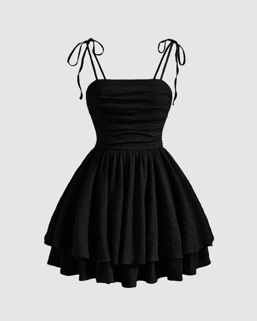 Front view of Black tie-shoulder cami mini dress with ruched bodice and layered skirt, shown front and back.
