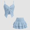 Two-piece dusty blue co-ord set featuring a twist front crop top and a tiered mini skirt with ruffles.
