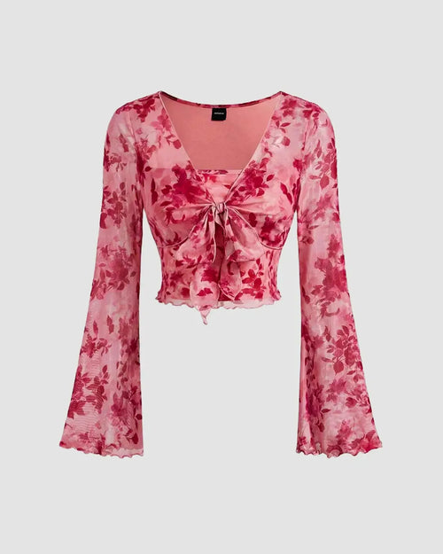 Front view of Floral print pink crop top with long bell sleeves and a stylish tie detail at the waist.
