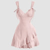 Front view of Powder pink V neck mini dress with tie straps and ruffle hem, featuring a fitted bodice and layered skirt