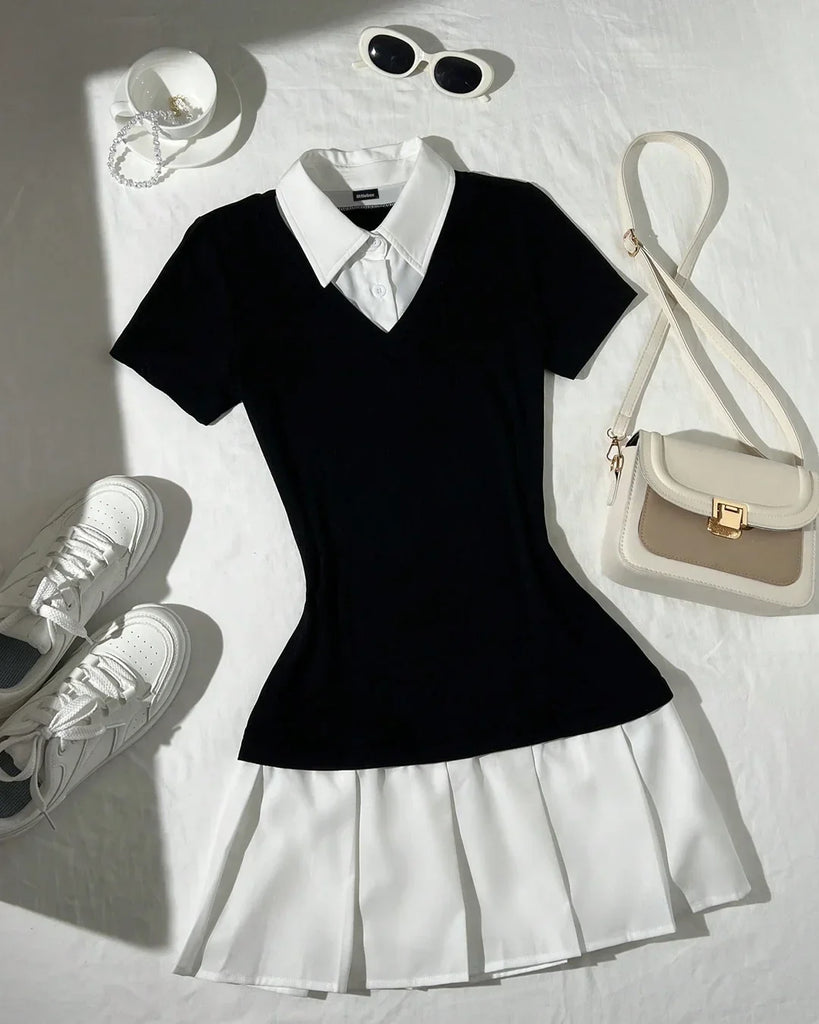 Black and white pleated dress with a white collar, paired with white shoes and a matching purse.