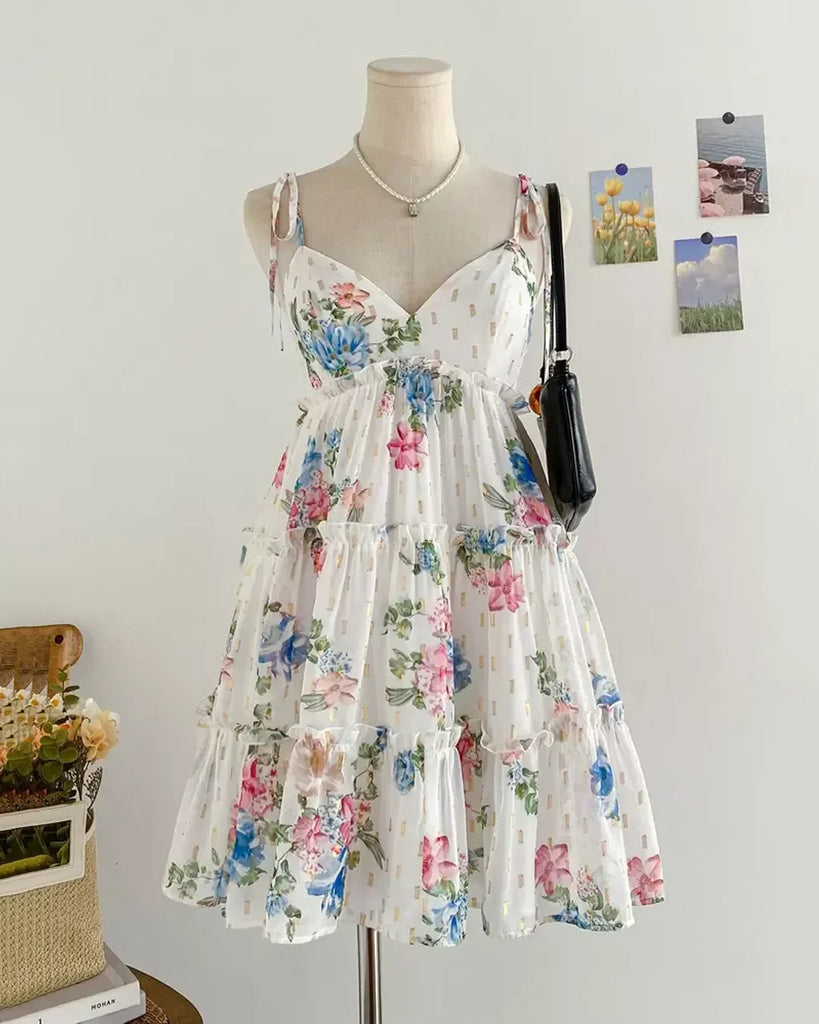White floral spaghetti strap fit and flare dress featuring a vibrant flower pattern on a light background.