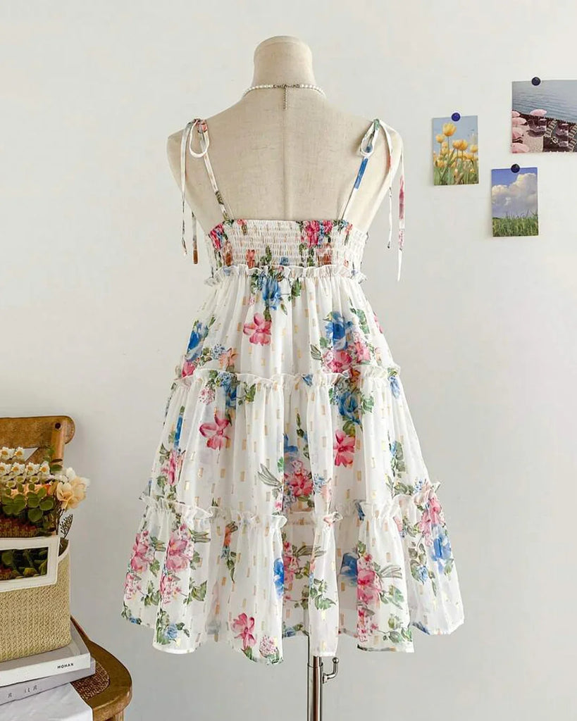 Back view of a White floral spaghetti strap fit and flare dress featuring a vibrant flower pattern on a light background.