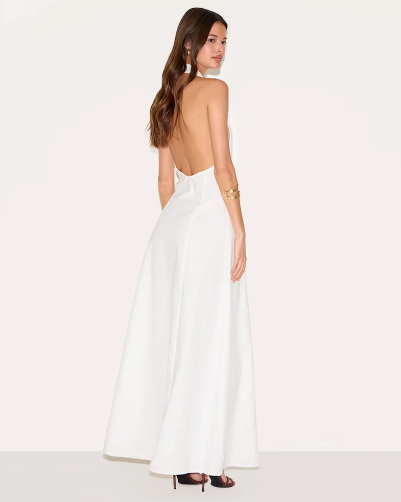 Back view of a White halter neck maxi dress featuring a deep neckline and a front slit, elegant and stylish for formal occasions.