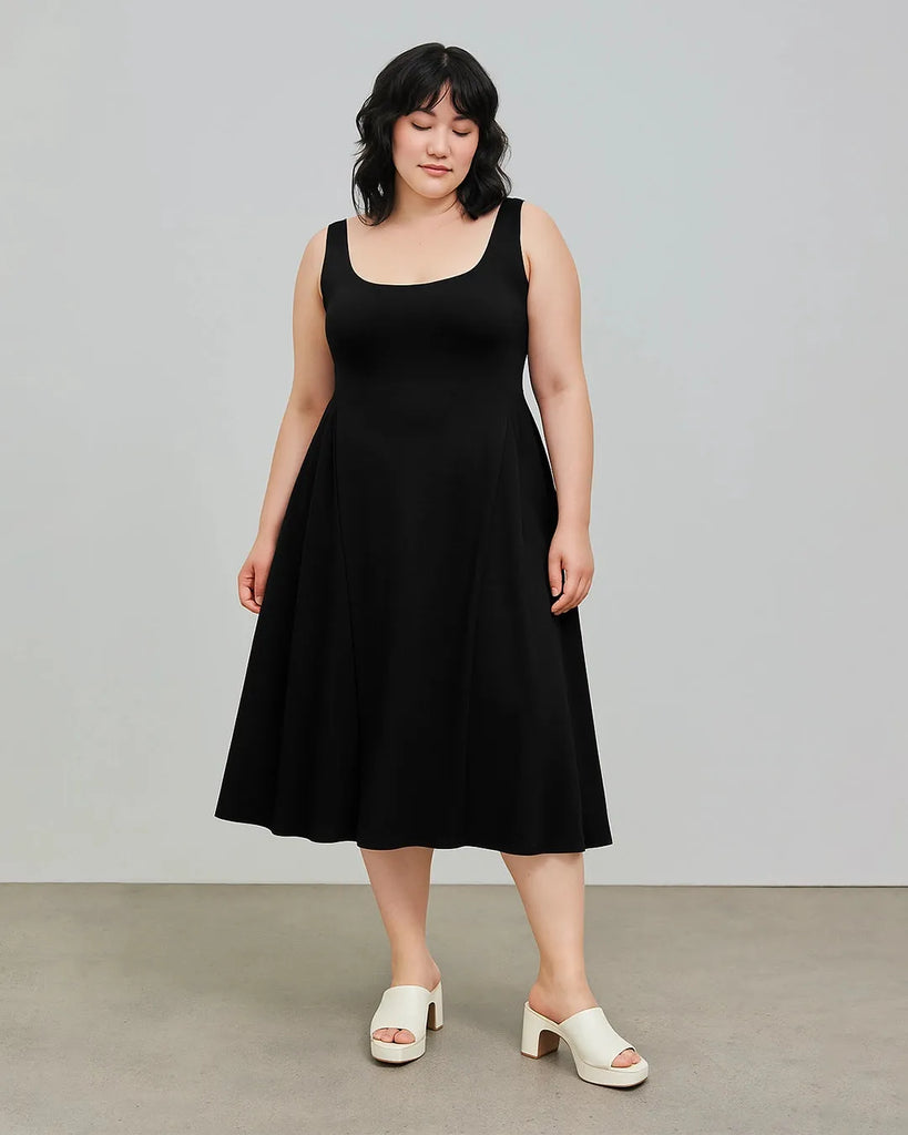 A woman models a black midi dress featuring a square neckline and ruffles, perfect for curve and plus-size fashion.