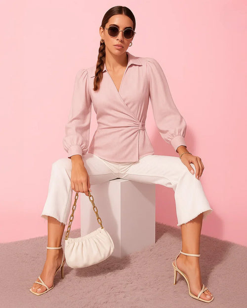 Women wearing v-neck powder pink wrap top with dramatic lantern sleeves and a cinched waist for a structured, elegant silhouette.