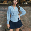 Women wearing Blue and white striped wrap-style top with long sleeves, shaped waist and crisp fabric for smart styling.