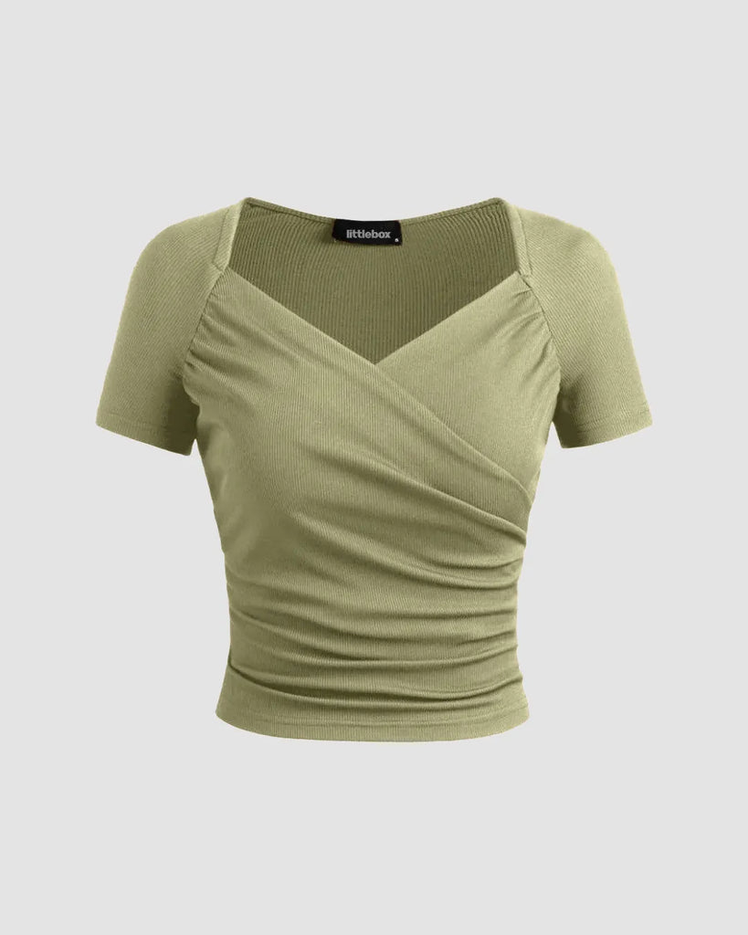 Sage green ribbed V-neck wrap top with short sleeves and a cinched waist, offering a flattering fit and soft structure