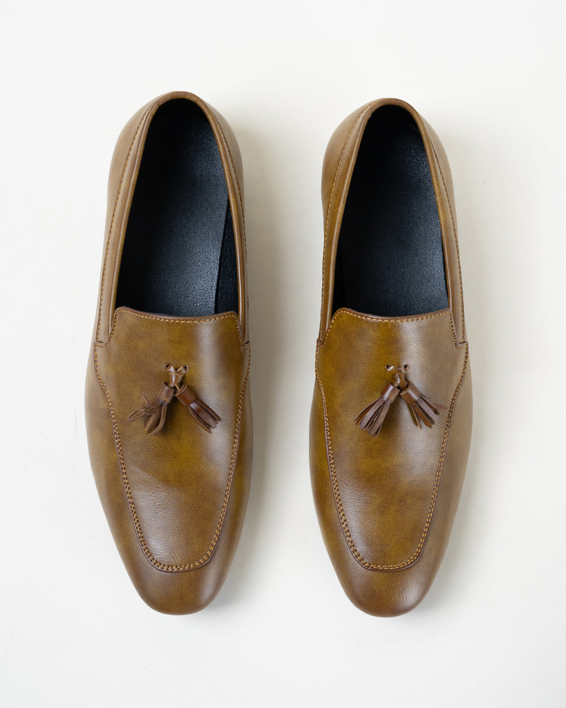 A pair of brown loafers with tassels.