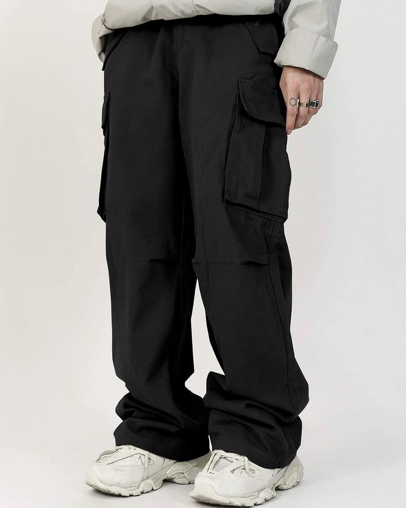 A man wearing black cargo pants and a white shirt.