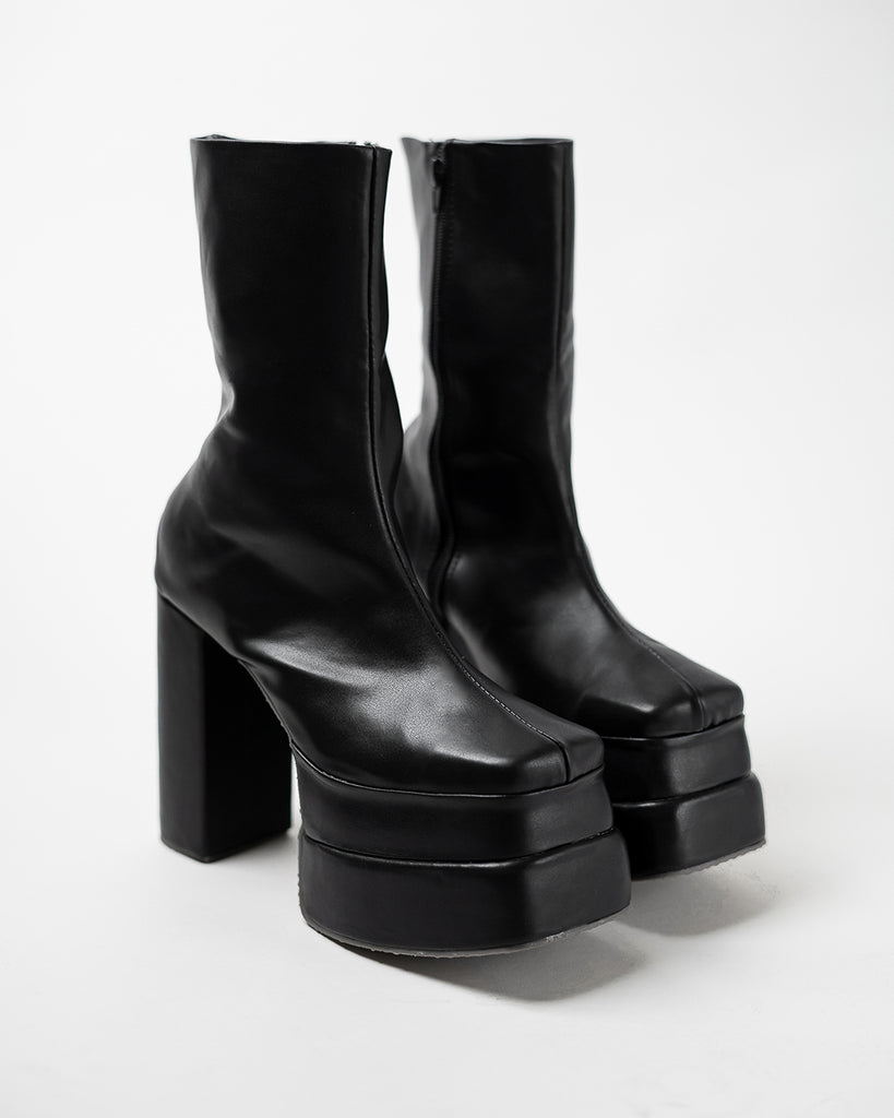 A pair of black platform boots on a white background.
