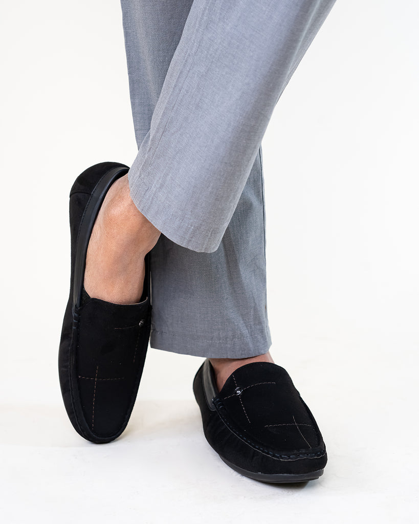 A Model wearing grey pants and seude loafers
