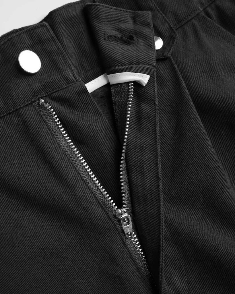 Zip of Y2K baggy fit women's cargo pants in black, featuring pockets and zippers.